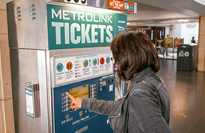 A woman buying a ticket from the Metrolink ticket machine